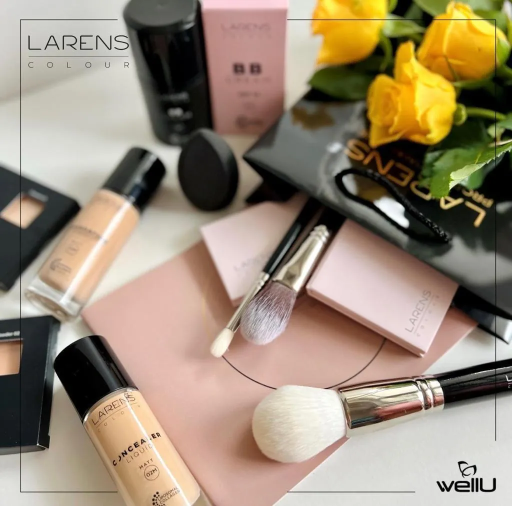Make-up-Produkte und Pinsel auf einer hellen Fläche, daneben gelbe Rosen.