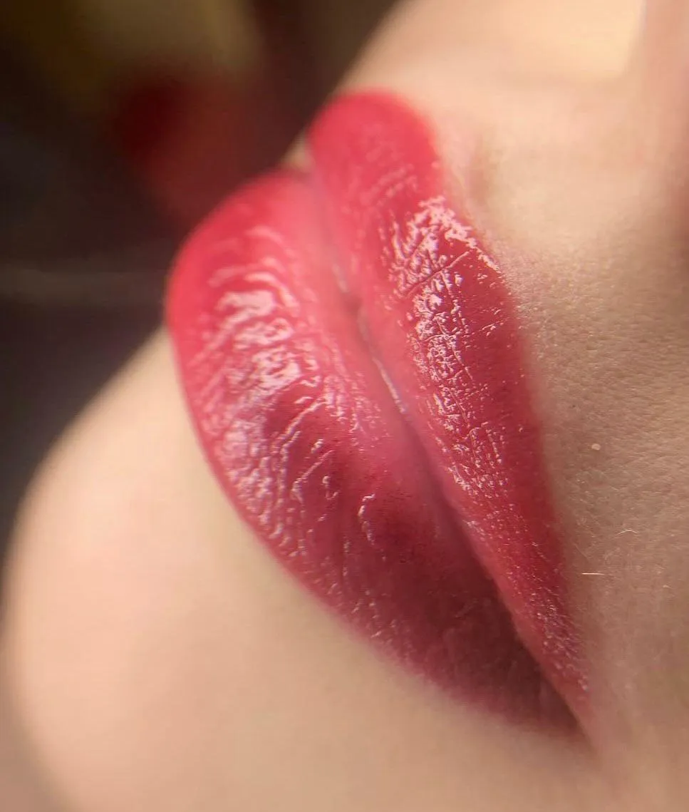 Nahaufnahme frisch pigmentierter Lippen in einem satten Beerenrot mit klarer Kontur.